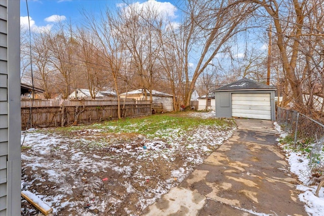 yard covered in snow with a garage and an outbuilding