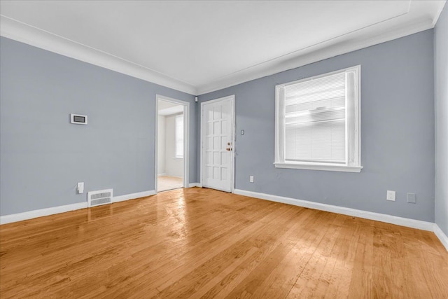 empty room featuring light hardwood / wood-style flooring and ornamental molding