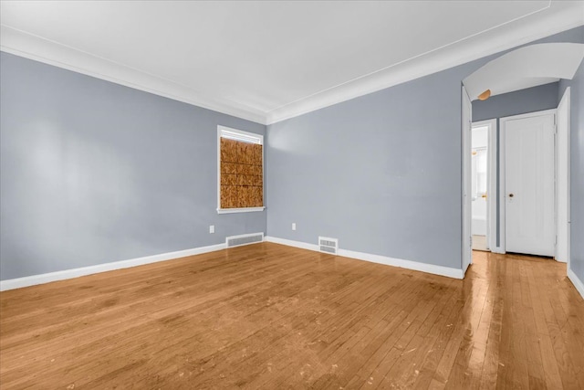 empty room featuring crown molding and light hardwood / wood-style floors