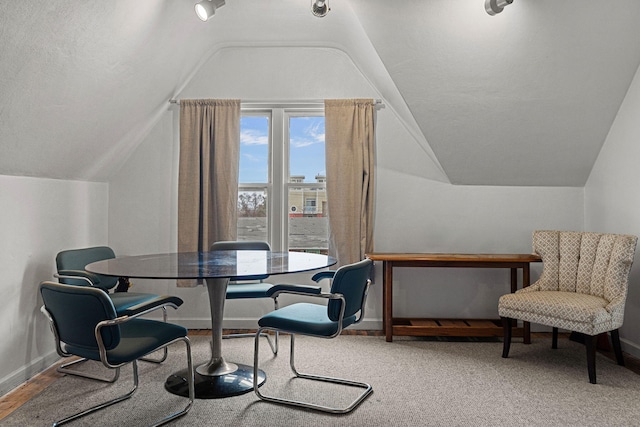 dining area featuring a textured ceiling and vaulted ceiling