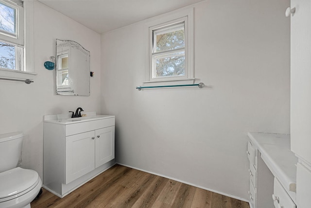 bathroom featuring wood-type flooring, vanity, and toilet