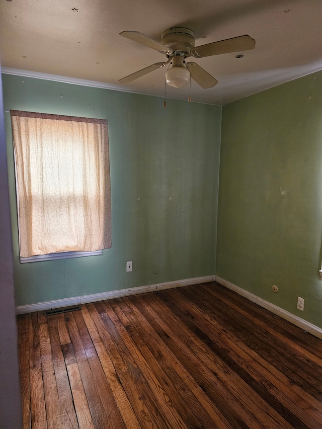 unfurnished room featuring ceiling fan, dark wood-type flooring, and ornamental molding