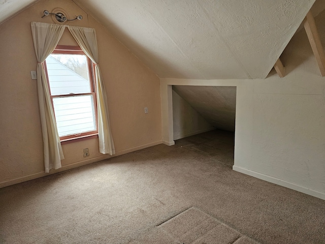 bonus room featuring carpet, lofted ceiling, and a textured ceiling