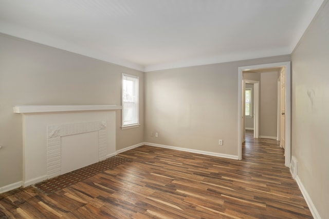 unfurnished living room featuring dark hardwood / wood-style floors and ornamental molding