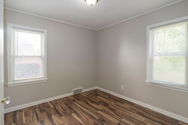 unfurnished room featuring dark wood-type flooring and ornamental molding