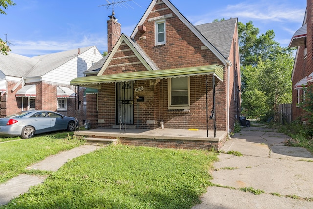 view of front of property featuring covered porch and a front lawn