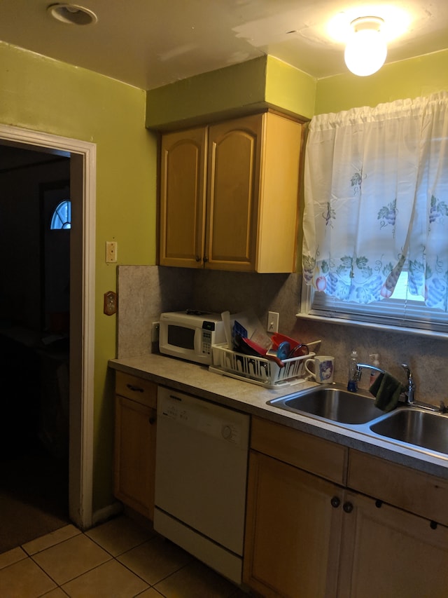 kitchen with light brown cabinets, white appliances, sink, and light tile patterned floors