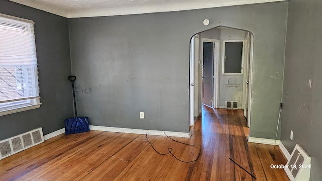 empty room featuring wood-type flooring and a textured ceiling