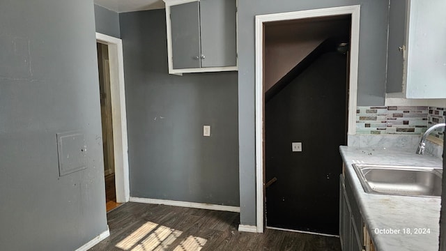 kitchen with dark wood-type flooring, tasteful backsplash, gray cabinetry, and sink