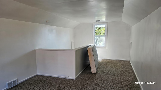 bonus room featuring vaulted ceiling and dark carpet