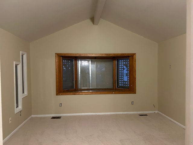 empty room featuring vaulted ceiling with beams and light carpet