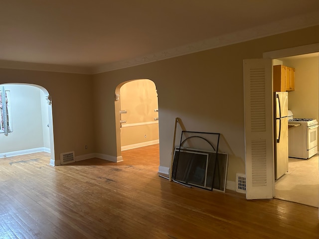 unfurnished living room with light hardwood / wood-style floors and ornamental molding