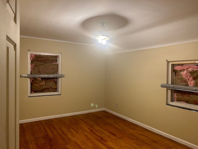 spare room with ornamental molding and dark wood-type flooring