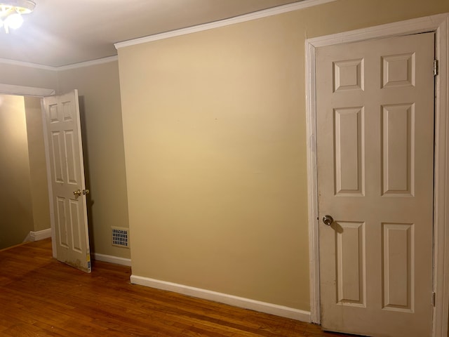 unfurnished room featuring hardwood / wood-style floors and crown molding