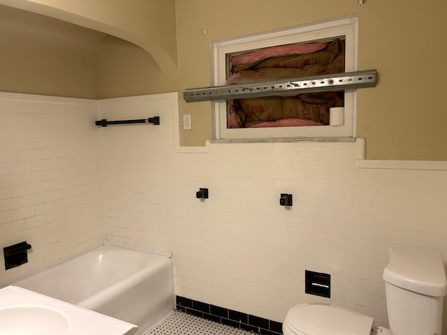 bathroom with sink, tile patterned floors, toilet, a bathtub, and tile walls