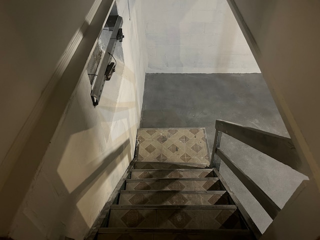 stairs featuring concrete flooring