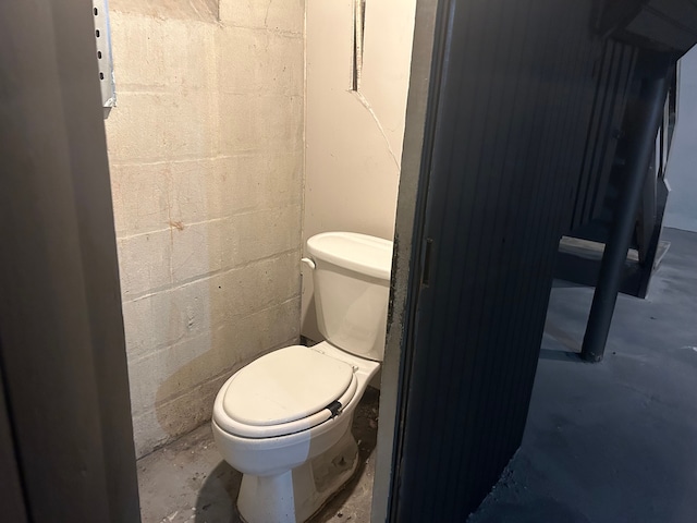 bathroom with concrete flooring and toilet