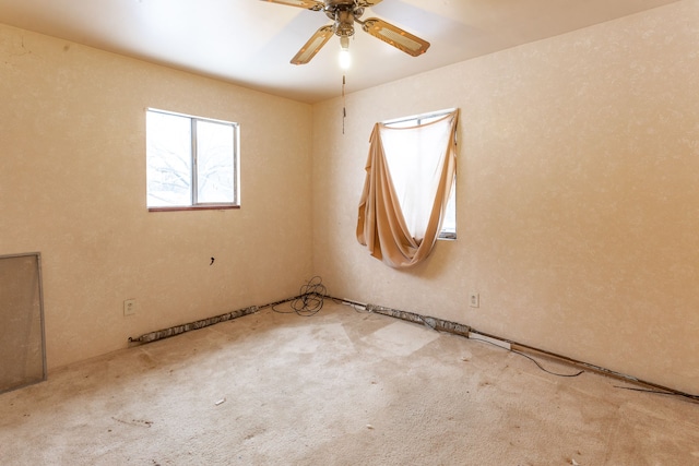 spare room with ceiling fan and light colored carpet