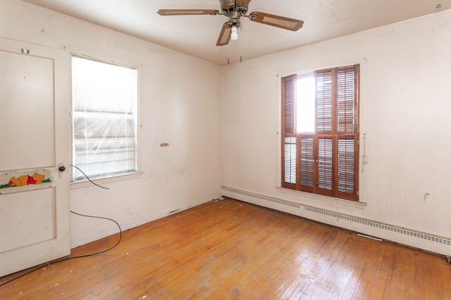 unfurnished room featuring hardwood / wood-style flooring, baseboard heating, and ceiling fan