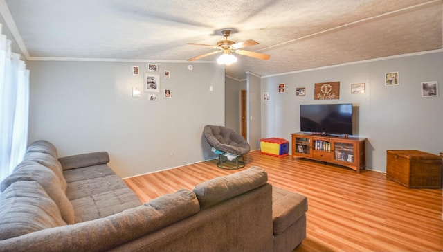 living room with hardwood / wood-style floors, a textured ceiling, ceiling fan, and crown molding