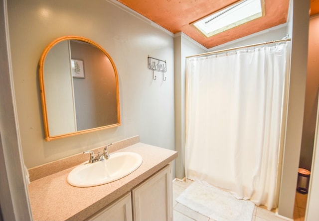 bathroom featuring tile patterned flooring, vanity, crown molding, and a skylight