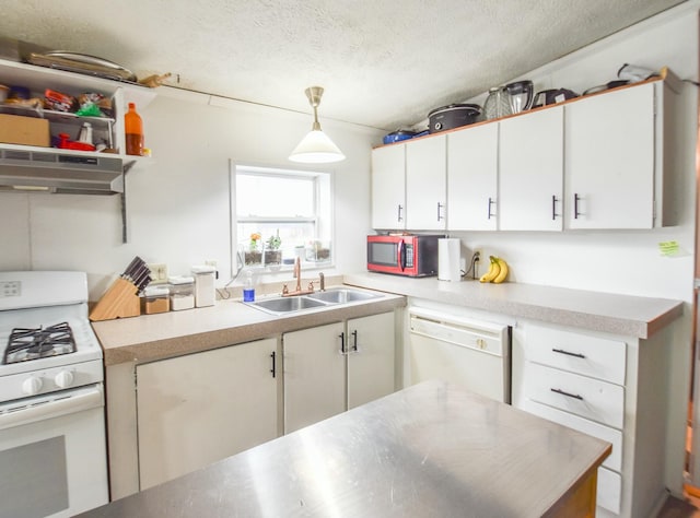 kitchen featuring white appliances, sink, hanging light fixtures, range hood, and white cabinetry