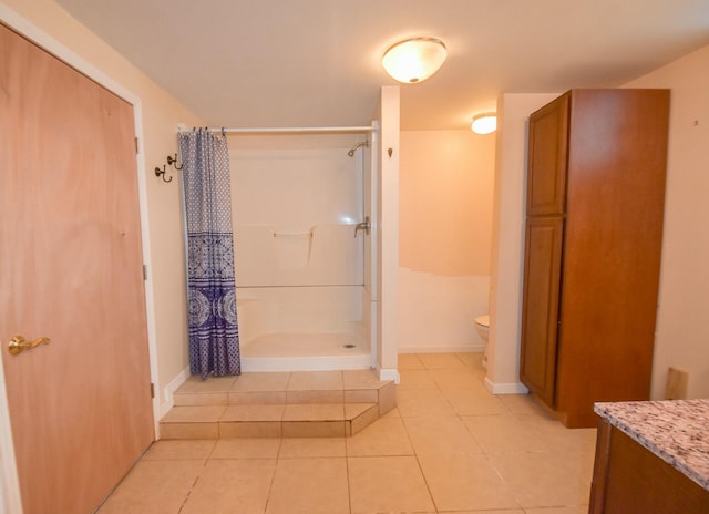 bathroom with tile patterned flooring, vanity, and walk in shower