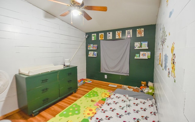 bedroom featuring light hardwood / wood-style floors, vaulted ceiling, and ceiling fan