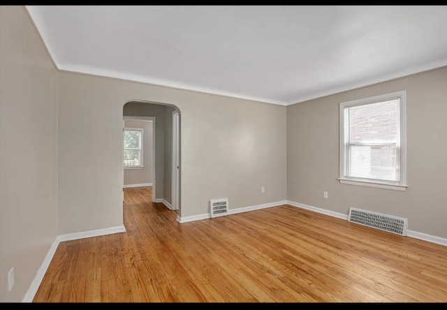 spare room featuring ornamental molding and light hardwood / wood-style flooring