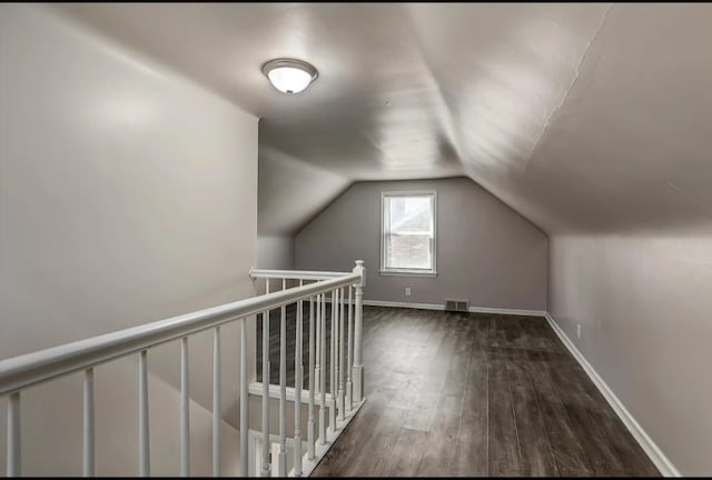 additional living space with dark hardwood / wood-style flooring and vaulted ceiling