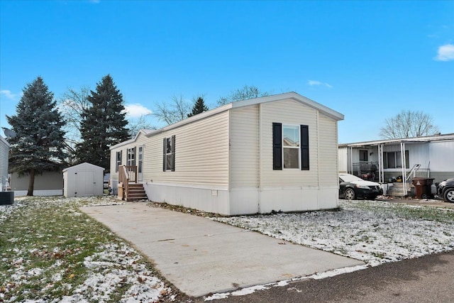 view of front facade with central AC unit and a storage unit