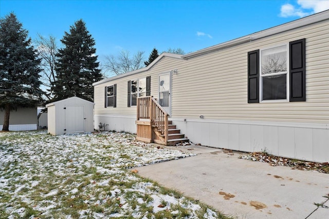 manufactured / mobile home with a shed and a patio area