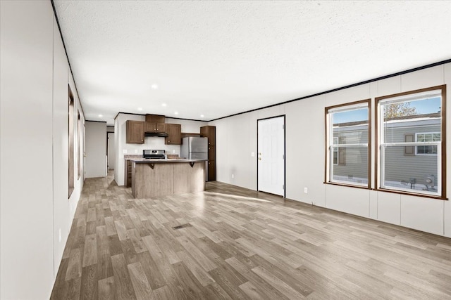 unfurnished living room with a textured ceiling and light wood-type flooring