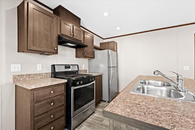 kitchen with appliances with stainless steel finishes, dark brown cabinetry, crown molding, sink, and light hardwood / wood-style floors