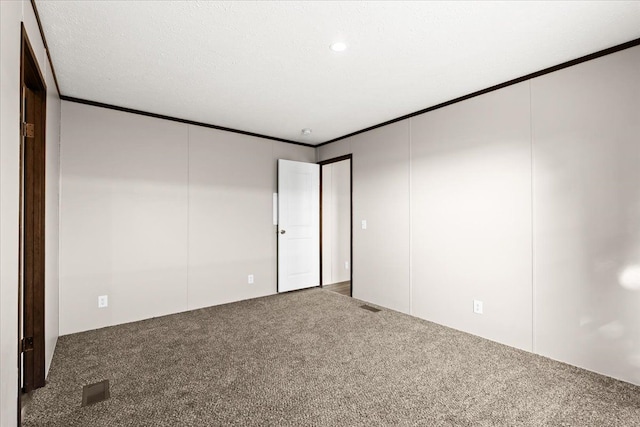 carpeted empty room featuring a textured ceiling and crown molding