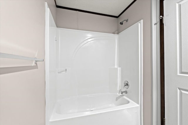 bathroom with shower / bath combination and a textured ceiling