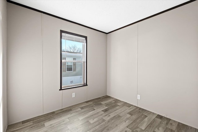 empty room featuring light hardwood / wood-style floors and crown molding