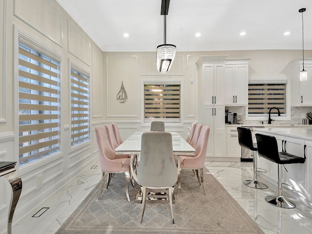 dining space with sink, a healthy amount of sunlight, and a notable chandelier