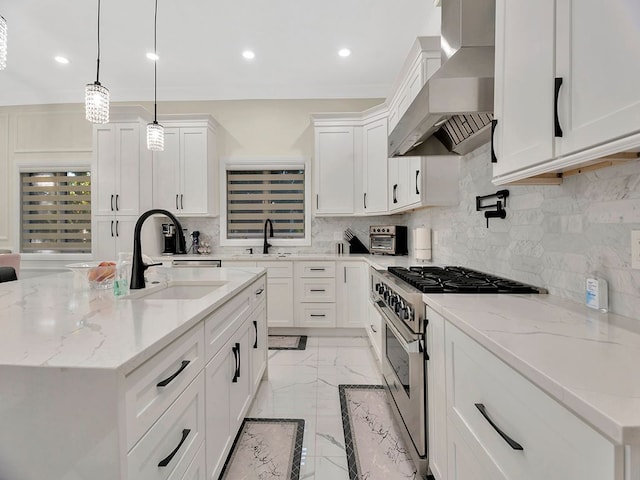 kitchen with white cabinets, decorative light fixtures, high end stainless steel range oven, and wall chimney range hood