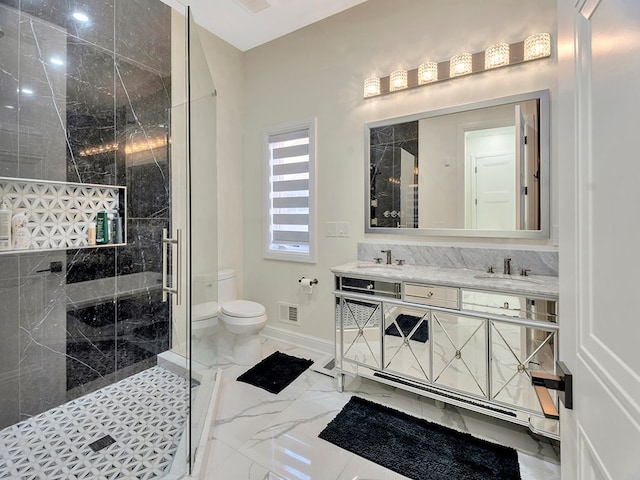 bathroom with tiled shower, vanity, and toilet