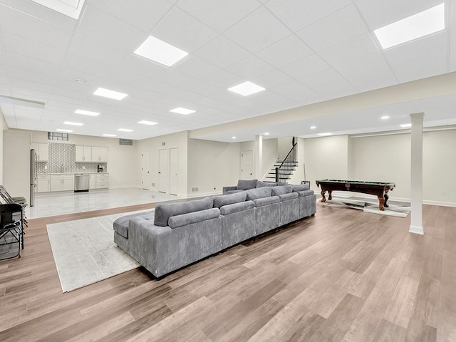 living room with a paneled ceiling and light wood-type flooring