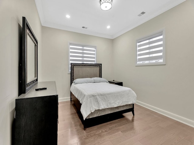 bedroom with crown molding and light wood-type flooring