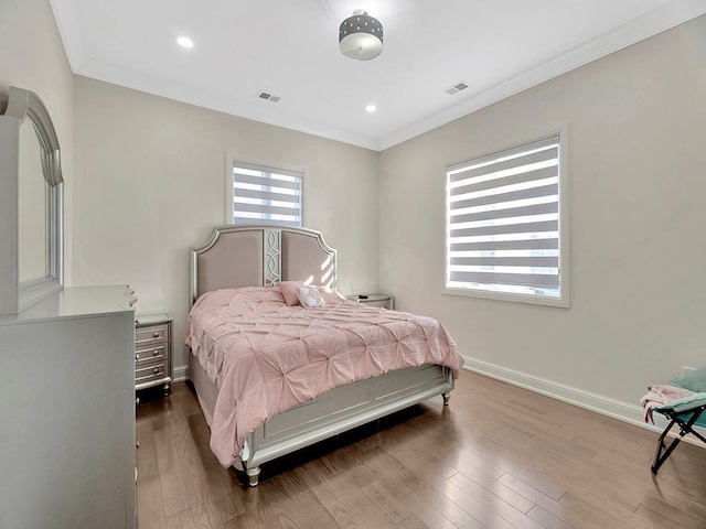 bedroom featuring crown molding and hardwood / wood-style flooring