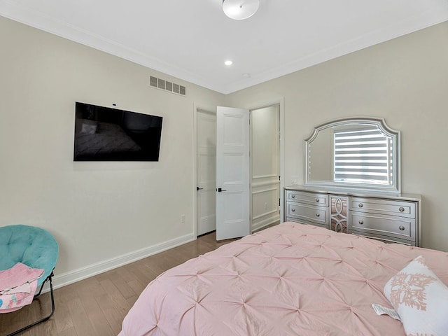 bedroom with hardwood / wood-style floors and crown molding