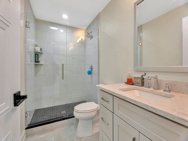 bathroom featuring tile patterned flooring, vanity, toilet, and a shower with shower door