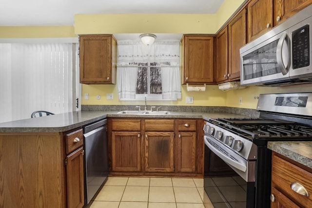 kitchen featuring kitchen peninsula, sink, light tile patterned floors, and stainless steel appliances