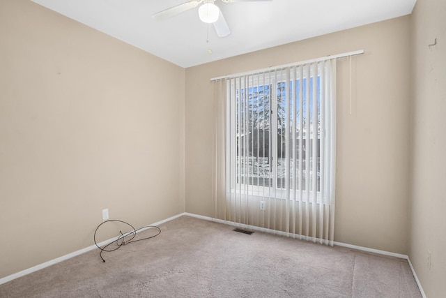 carpeted spare room with ceiling fan