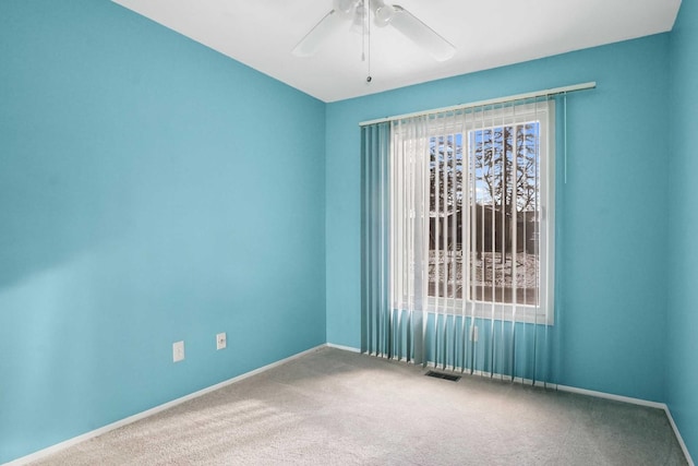 carpeted spare room featuring ceiling fan