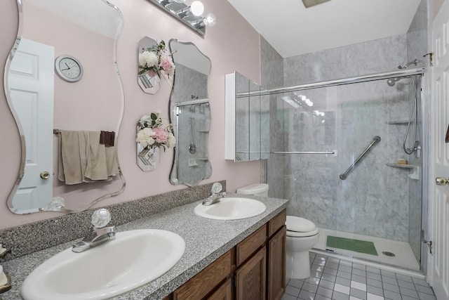 bathroom featuring tile patterned flooring, vanity, toilet, and an enclosed shower