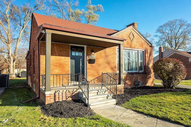 view of front of home featuring covered porch and a front lawn